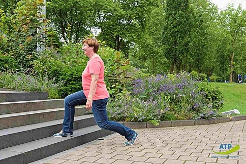 ATP Übung 9 Ältere Frau macht einen Ausfallschritt an einer Treppe