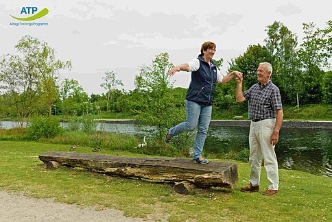 ATP Übung 8 2 ältere Menschen balancieren auf einem Baumstamm