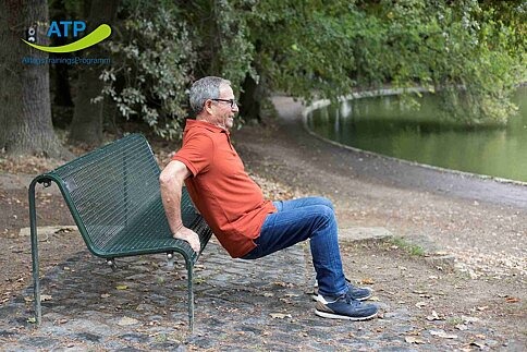 ATP-Dauerangebot Übung 7 Älterer Mann macht Stützbeuge an einer Bank