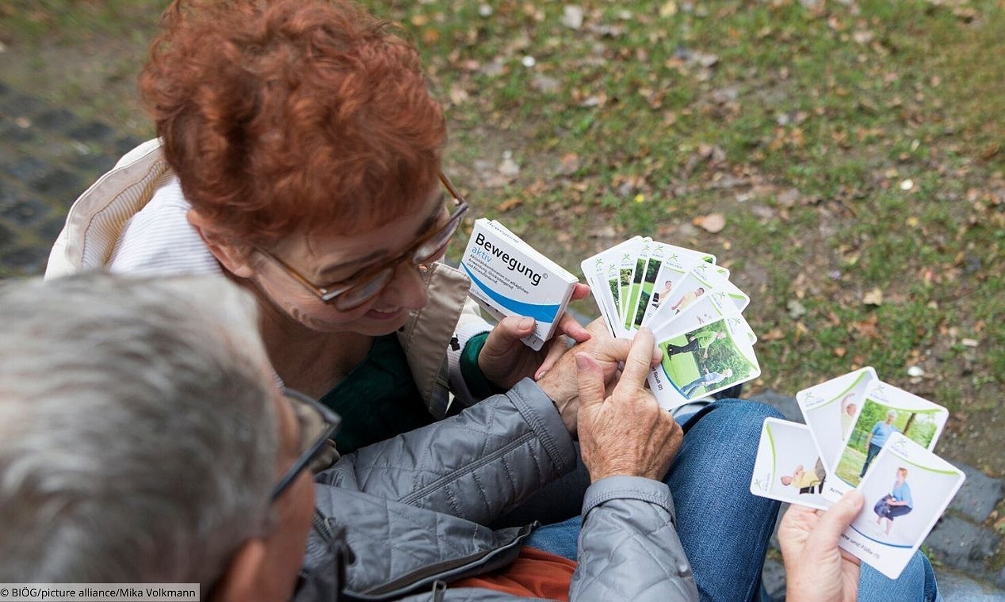 Materialien zum AlltagsTrainingsProgramm (ATP) Gruppe älterer Menschen mit Karten der Bewegungspackung