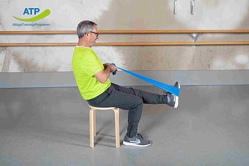 ATP-Dauerangebot Übung 1 Älterer Mann dehnt Oberschenkel im Sitzen