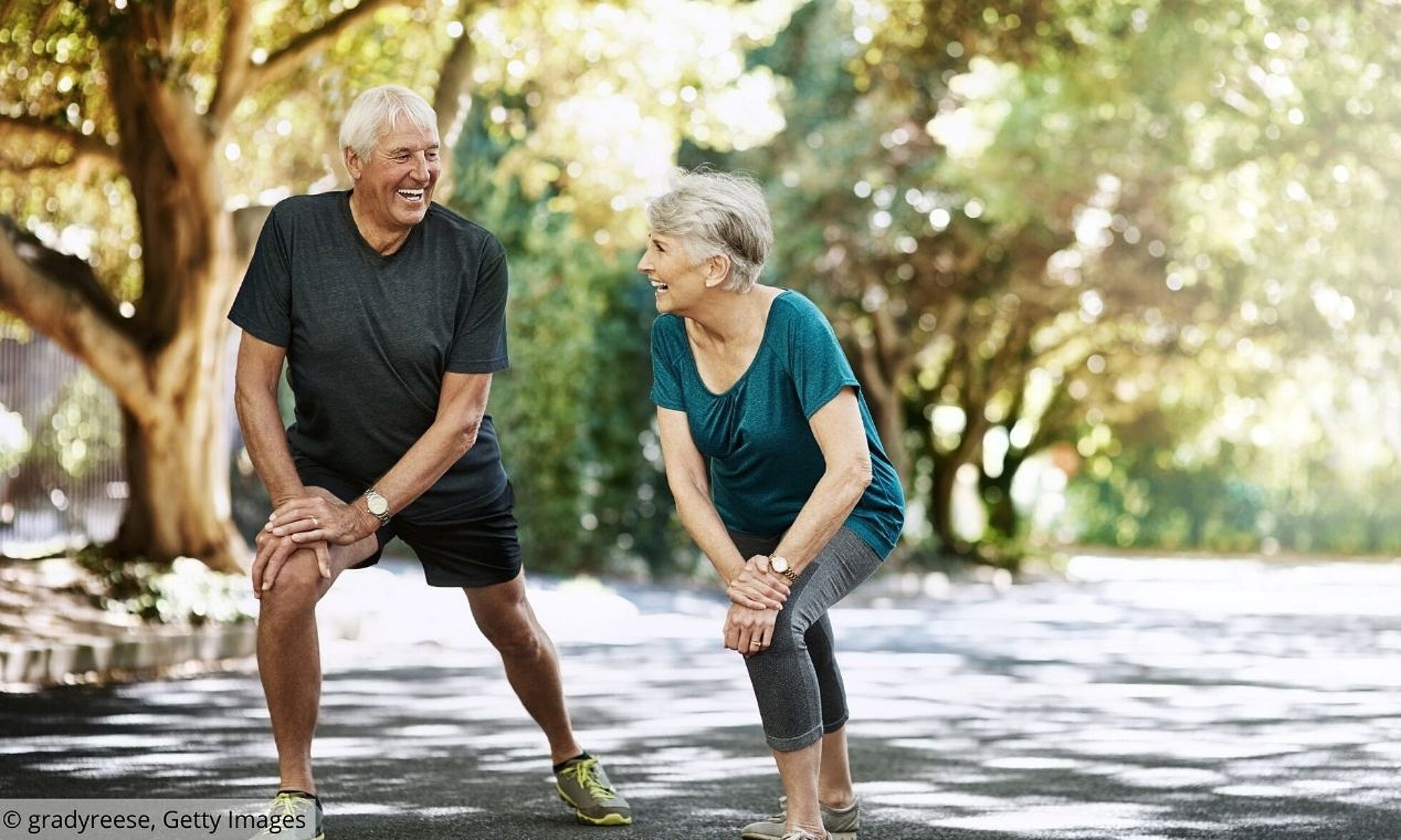 Aktiv bei Hitze Älterer Mann und Frau machen Sportübungen im Park